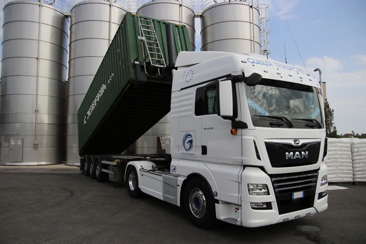 Truck unloading shipping container outdoors