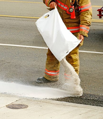 Firefighter spreading corncob on road
