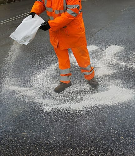 Person spreading corn cob on pavement